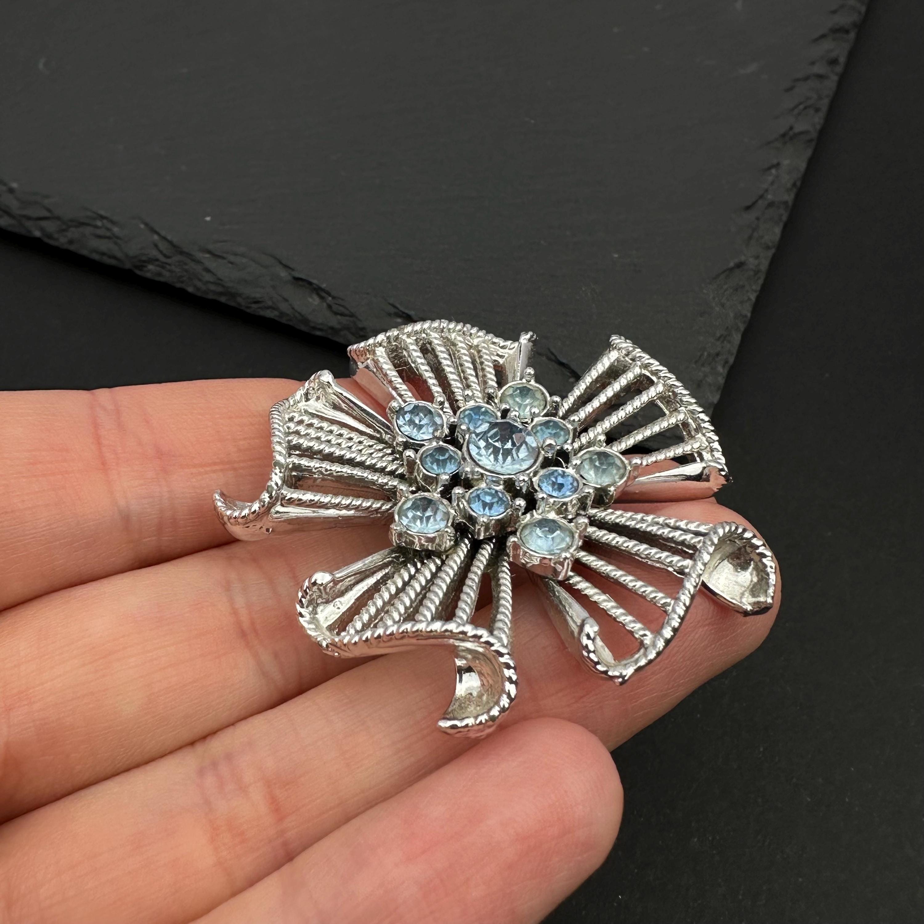 Vintage silver tone and blue rhinestone flower brooch
